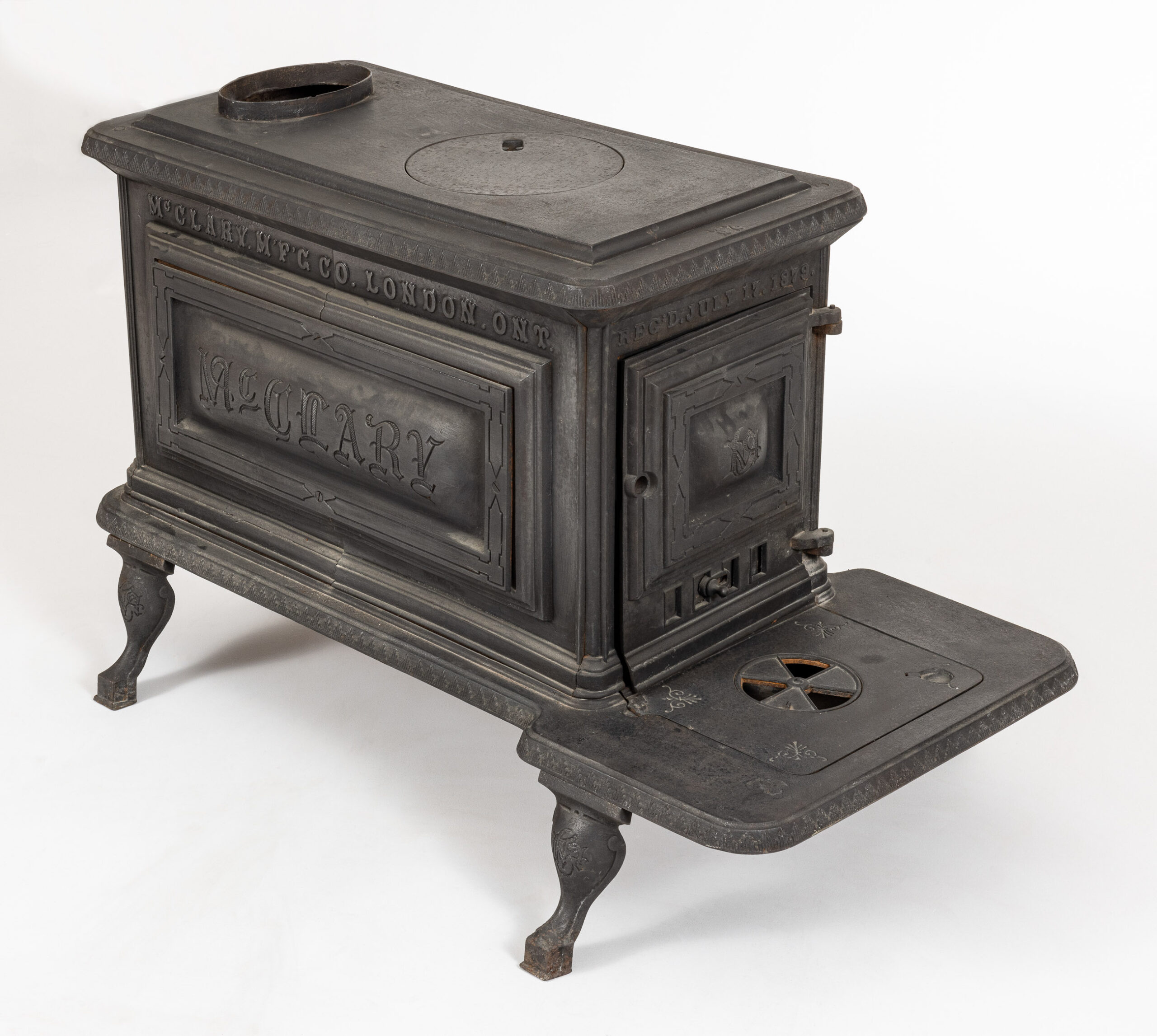 The cast iron stove is faded, but still looks in pristine and well-cared for condition. You would never know it was well over 100 years old. It is rectangular, with the door on the short angle. A shelf sites under the door to help with loading and unloading savoury dishes from inside.